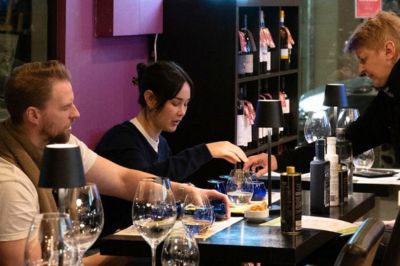 Travelers tasting Greek extra virgin olive oil during a guided olive oil tasting experience in Athens.