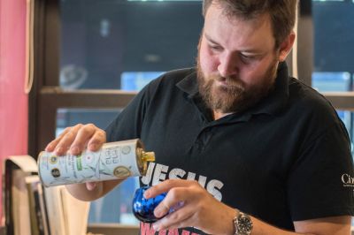 Greek extra virgin olive oil being poured into a blue tasting glass for an olive oil tasting in Athens.